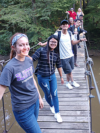 Students in the nature preserve on the swinging bridge